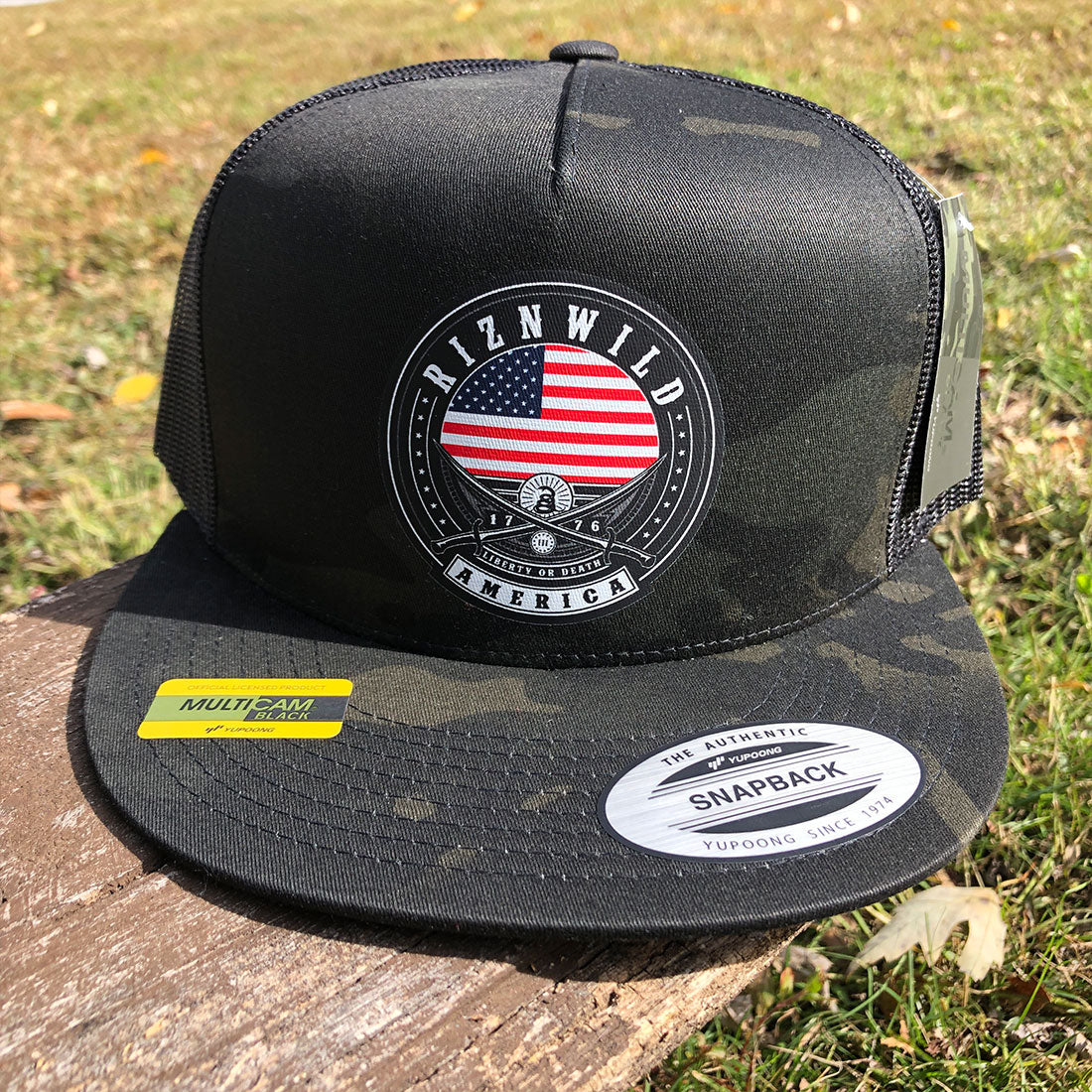 Side profile of RIZNWILD Liberty Trucker Hat showing mesh back and MultiCam Black design