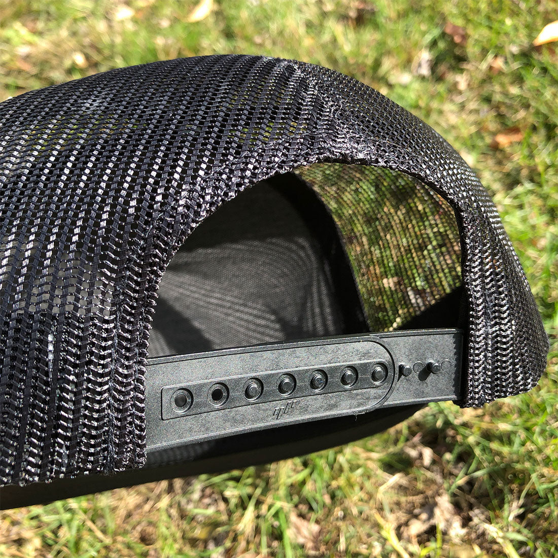 Adjustable snapback closure of RIZNWILD Liberty Trucker Hat with black mesh back