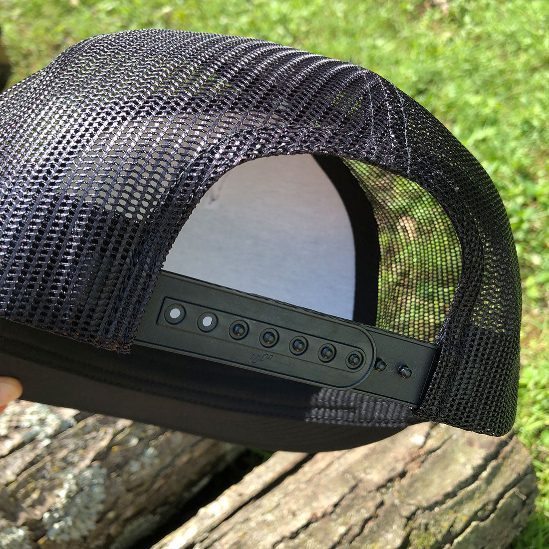 A black mesh-back trucker hat with snap back.