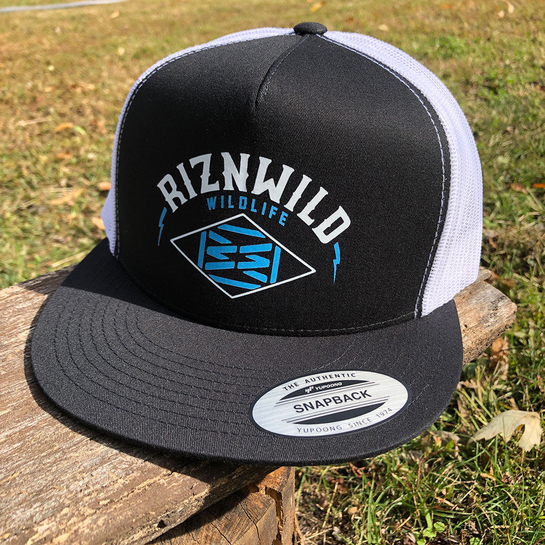 "Side and back view of RIZNWILD black flat brim hat with white mesh and snapback closure."