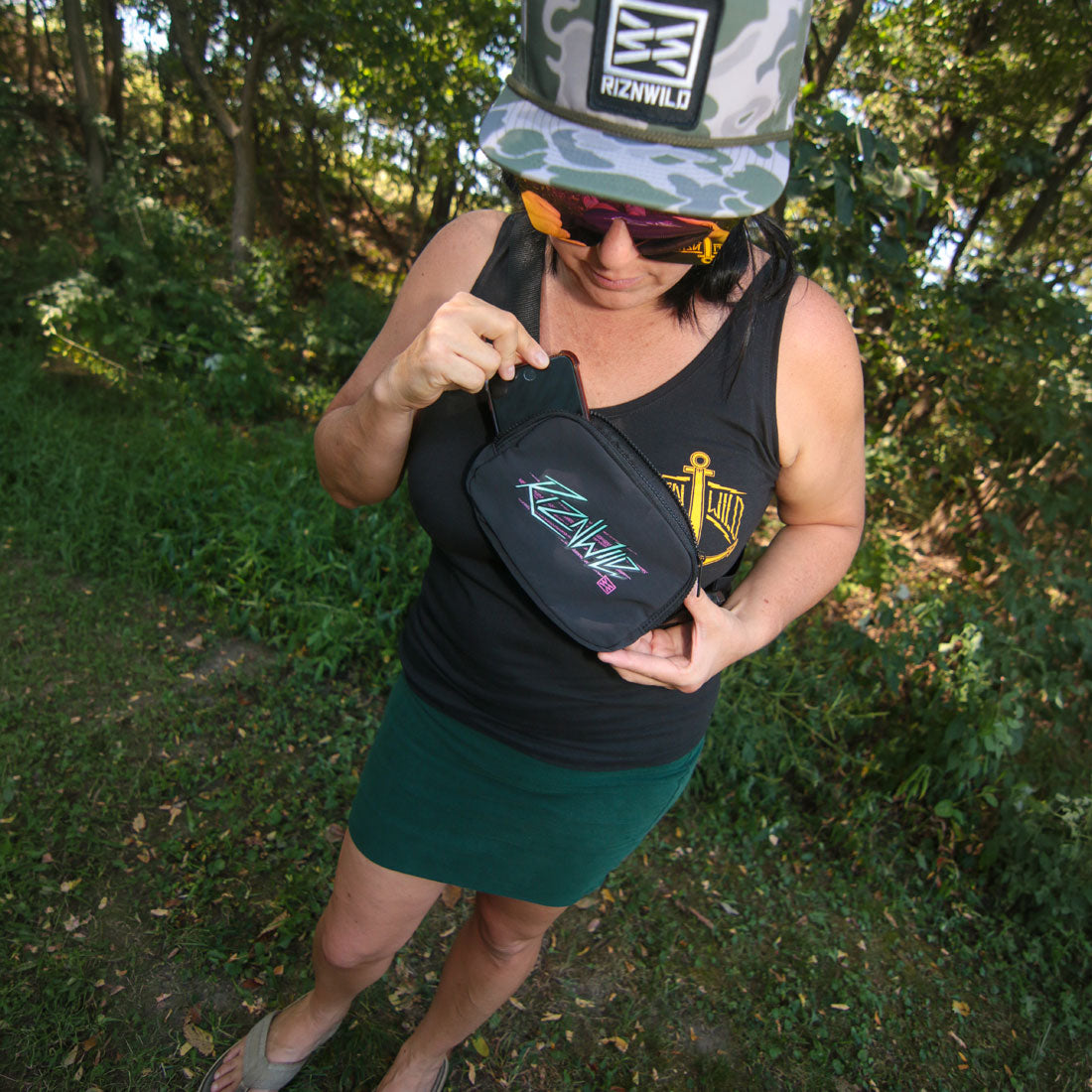 Woman opening the RIZNWILD Electra crossbody bag
